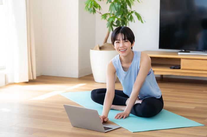 Japanese woman doing yoga in her living room (People)