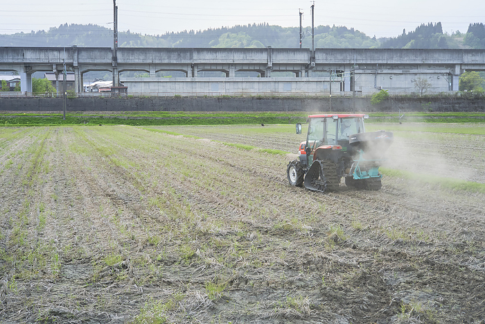 Photographed in 2024 Rice cultivation in Minamiuonuma   Fertilizer application April 2024 Minamiuonuma City, Niigata Prefecture Spraying fertilizer containing minerals and other substances before raising rice paddies. The Joetsu Line and Joetsu Shinkansen tracks can be seen in the background.