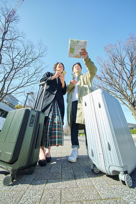 Japanese man and woman lost with suitcases (People)