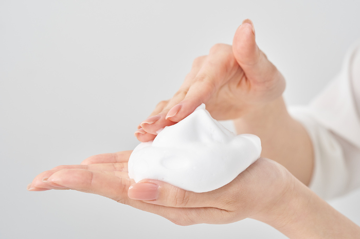 A woman's hand placing a fine lump of foam in her palm