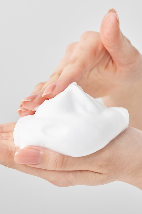 A woman's hand placing a fine lump of foam in her palm