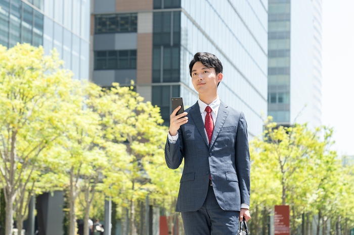 Young Japanese businessman holding a cell phone (People)