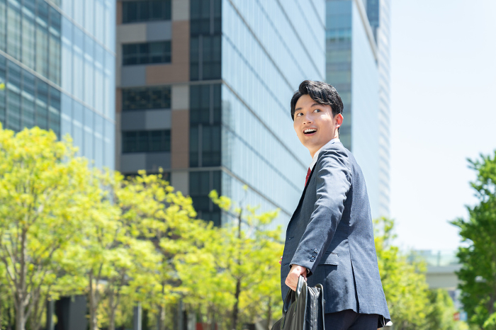 Young Japanese businessman running.