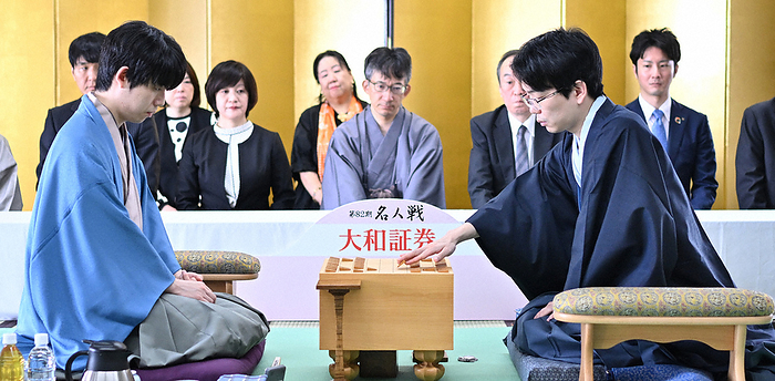 The 82nd Meijin Tournament   7th game   3rd game   1st day At the start of the 3rd game of the 82nd Meijin Tournament, Masayuki Toyoshima 9 dan  right  makes his second move after receiving the first move by Sota Fujii Meijin  left . In the center is Yasumitsu Sato 9 dan, witnessing the game, at Haneda Airport Terminal 1 on May 8, 2024 at 9:01 a.m. Photo by Koichiro Iwashita