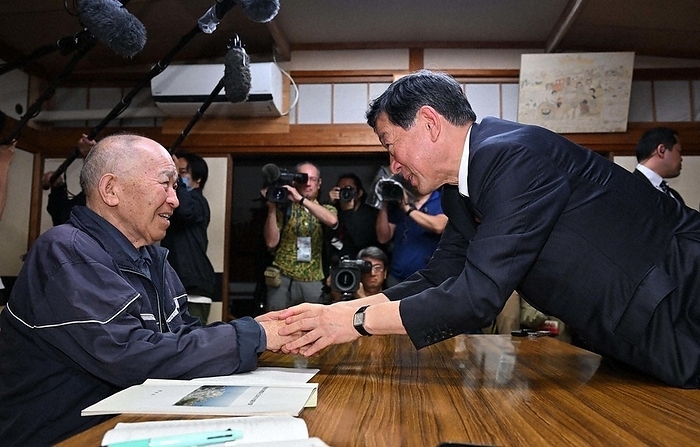 Environment Minister Shintaro Ito shakes hands after apologizing. Minister of the Environment Shintaro Ito visits Shigemitsu Matsuzaki  left , vice president of the Minamata Disease Patients Coalition, who was prevented from speaking at a meeting between patients and victims of Minamata disease and the government, and after apologizing, shakes hands with him.
