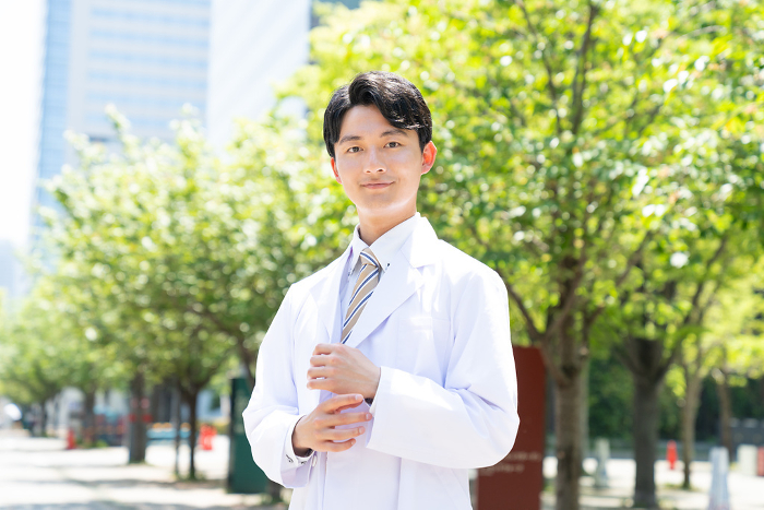 Young Japanese man in white coat.