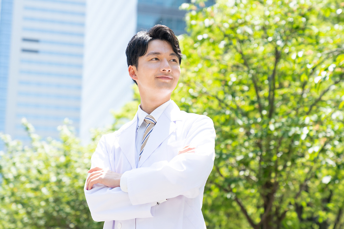Young Japanese man in white coat.