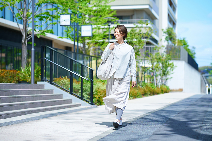 Japanese woman walking down the street with a shopping bag (People)