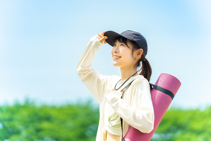 Smiling Japanese woman heading outdoors to play sports (People)