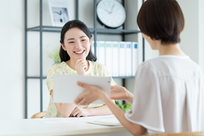 A young Japanese woman being briefed by a businesswoman (People)