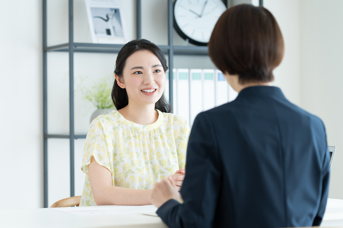 Young Japanese woman consulting with businesswoman (People)