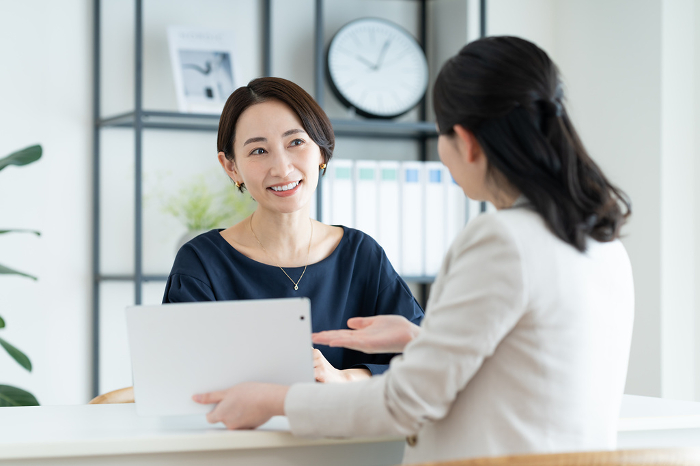 A Japanese woman in the middle consulting with a client.