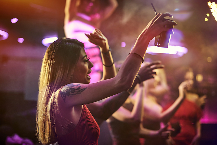 A joyful night out with friends captured as a woman dances in a vibrant club atmosphere.