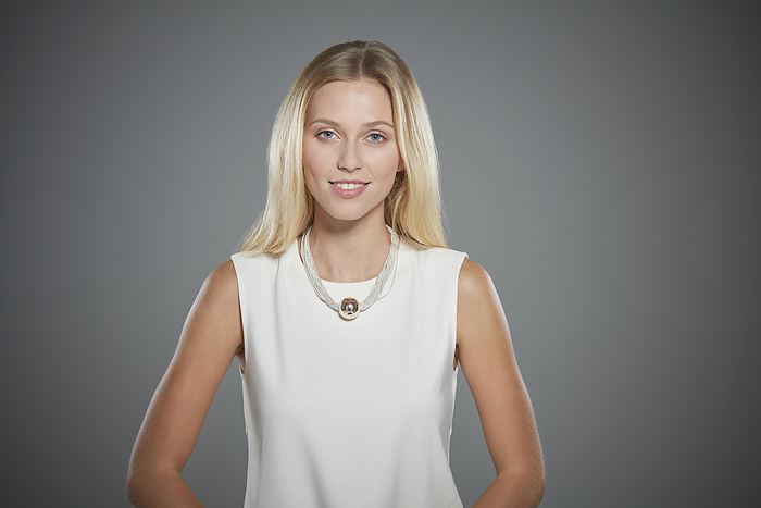 Smiling blonde woman in a white sleeveless top posing for a portrait
