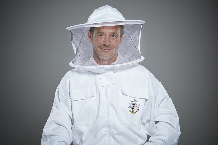 Beekeeper in protective suit posing with confidence