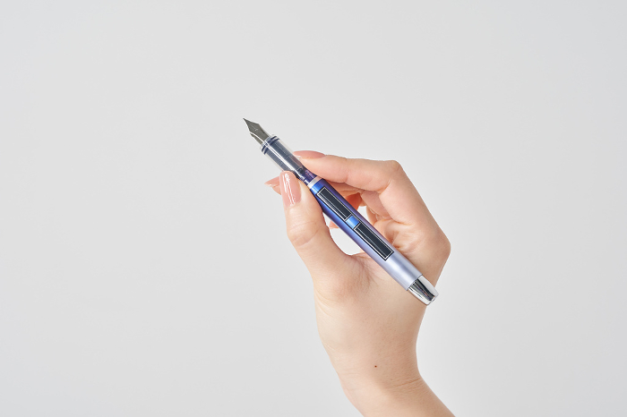 Woman's hand with fountain pen and white background