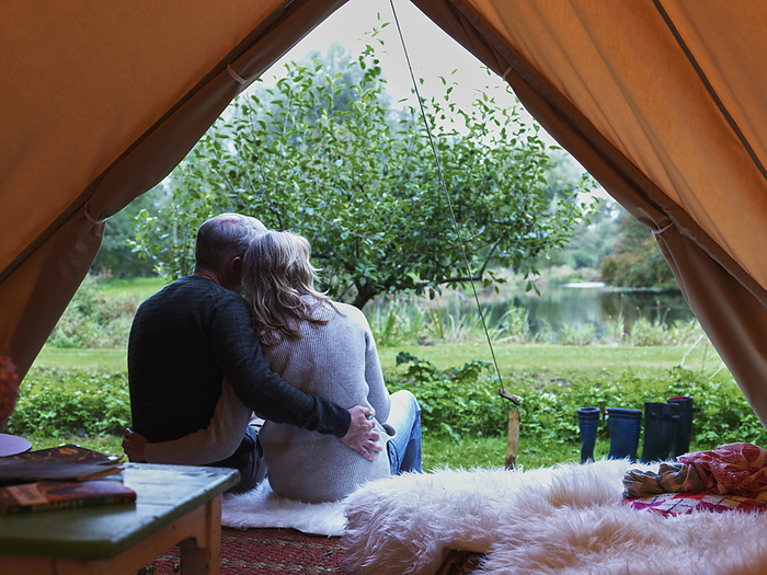 Mature married couple sitting in tent together.