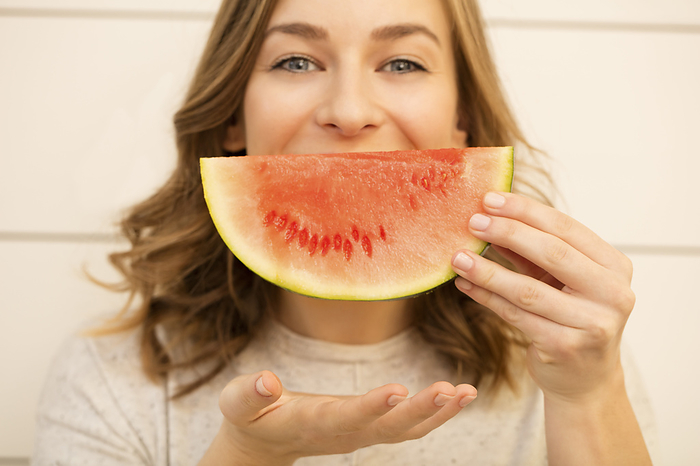 Young woman holding watermelon slice