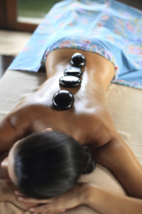 Young woman getting lastone therapy on her back