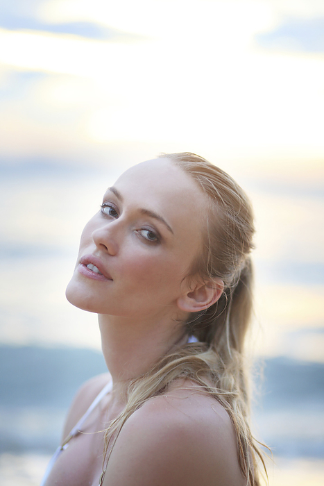 Portrait of young woman on beach at sunset