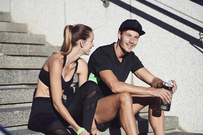 Fitness training Couple wearing sportswear sitting on staircase