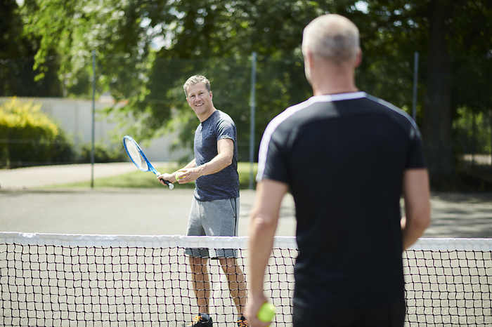 Mature men playing tennis