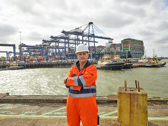 Dock worker at Port of Felixstowe, England infront of huge container ship