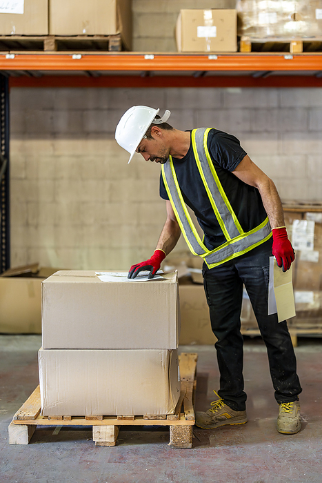 Worker examining checklist at wood distribution warehouse