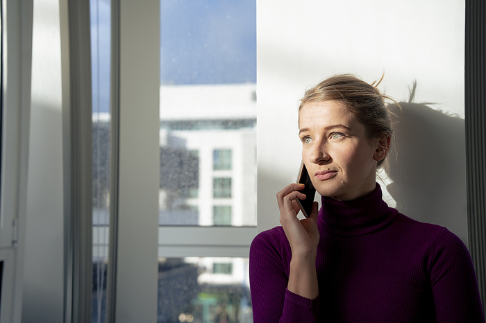 Serious businesswoman talking on smart phone in office