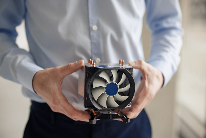 Mature engineer holding CPU fan at workshop