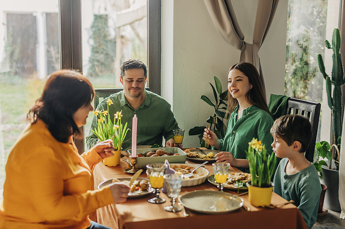 Happy family enjoying meal on dining table at Easter dinner