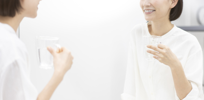 Japanese woman checking her teeth in a mirror.