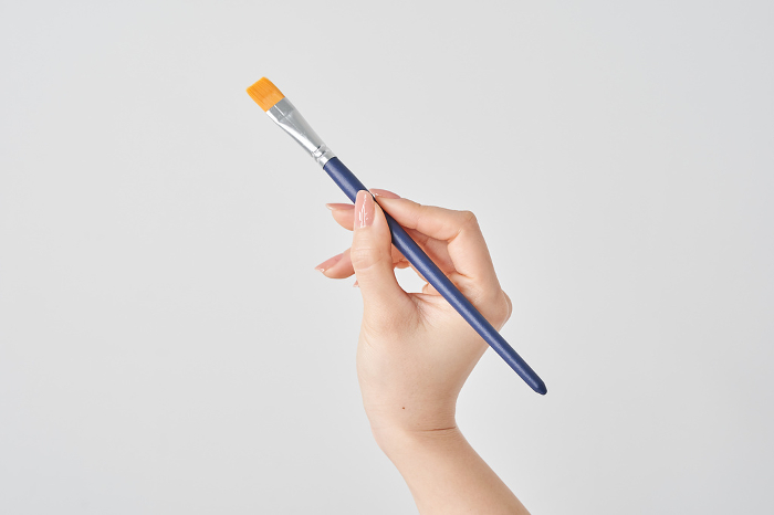Woman's hand holding a paintbrush