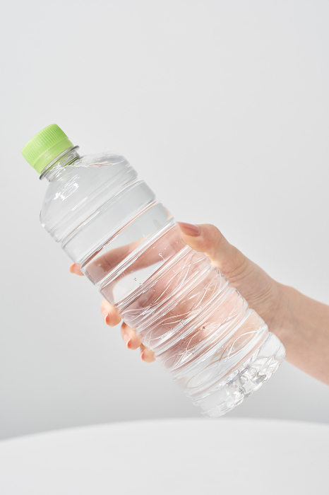 Woman's hand holding a plastic bottle of water