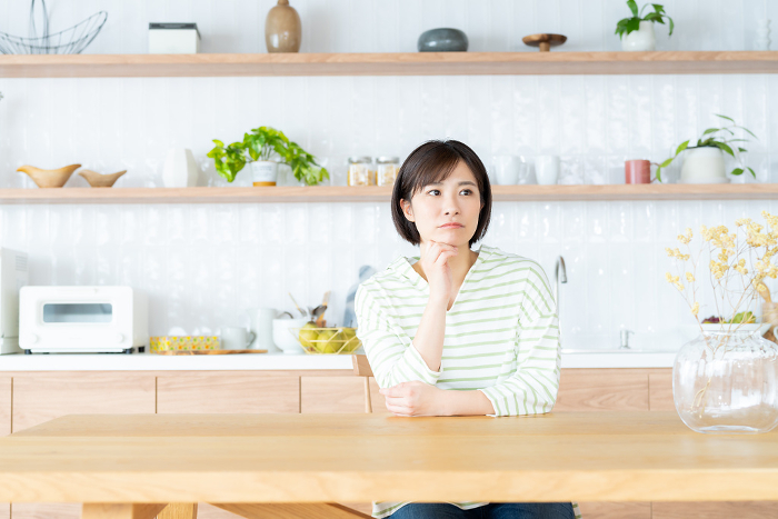 Kitchen. Young Japanese woman in dining room.