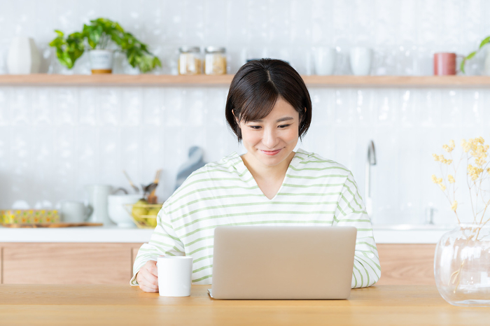 Young Japanese woman using a computer in the dining room (People)