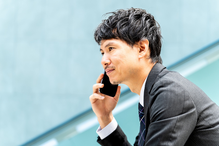 Japanese male businessman talking on his cell phone (People)
