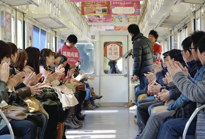 Red Threads Connected by Railroad Tracks Iron Contest  on the Nankai Kata Line Participants introduce themselves on board the train  on the Nankai Electric Railway Kata Line in Wakayama City , photo taken on March 9, 2014.