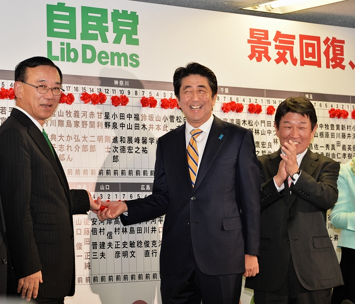 House of Representatives Election 2014 Autocratic victory and continuation of power December 14, 2014, Tokyo, Japan : Japan s Prime Minister and ruling Liberal Democratic Party  LDP  president Shinzo Abe C  and Sadakazu Tanigaki, Secretary General of the Liberal Democratic Party L  put up roses on victorious candidates  names at his LDP headquarters in Tokyo while ballot counting goes on for the general elections on December 14, 2014.  Photo by AFLO 