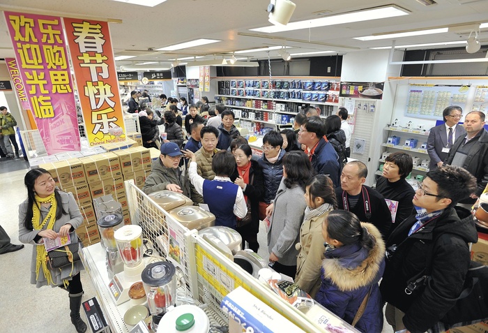 Chinese customers crowded into an electronics store in Akihabara, Tokyo. Inside an electronics retail store crowded with Chinese customers. A banner reading  Happy Chinese New Year  in Chinese hangs down  at the main store of LaOX in Akihabara, Tokyo, on February 5, 2011 . Photo taken on the morning of February 5, 2011. The photo was published in the evening edition of the same February 5, 2011. The  Chinese New Year shopping season  is in full swing, targeting Chinese tourists visiting Japan for the Chinese New Year holiday. Retailers and travel agencies are eager to increase sales by targeting Chinese tourists with high purchasing power.