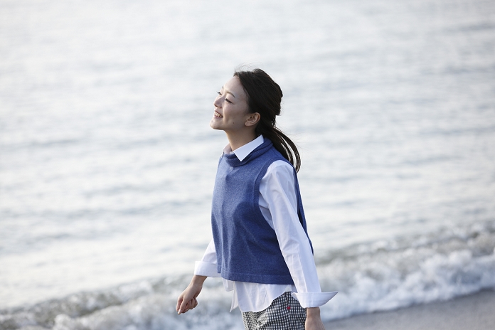 Japanese woman walking on the beach