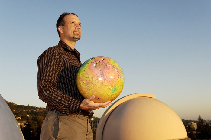 Jeffrey Marcy  2005   BProfessor Geoffrey Marcy, b astrophysicist, holding a globe of the planet Mars. Marcy is one of the world s leading researchers into planets around stars other than our Sun. He is professor of astronomy at University California, Berkeley, USA. In 1995 he confirmed the discovery of the first extrasolar planet around a sun like star,  I51 Pegasi B i  discovered by Didier Queloz and Michael Mayor . Together with his team, he has since discovered over 110 other planets including: the smallest planet, around I Gliese 876 i , and the first multiple planet system, around I Upsilon  IAndromedae. i Photographed in 2005.