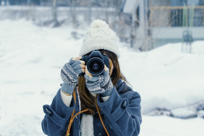 Japanese woman holding a camera in the snow