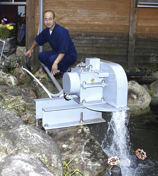 Prefectural version, hot spring power generation President Sakurai pours hot water into a jet water turbine generator at Koma no yu Sanso in Uonuma City, Niigata Prefecture.