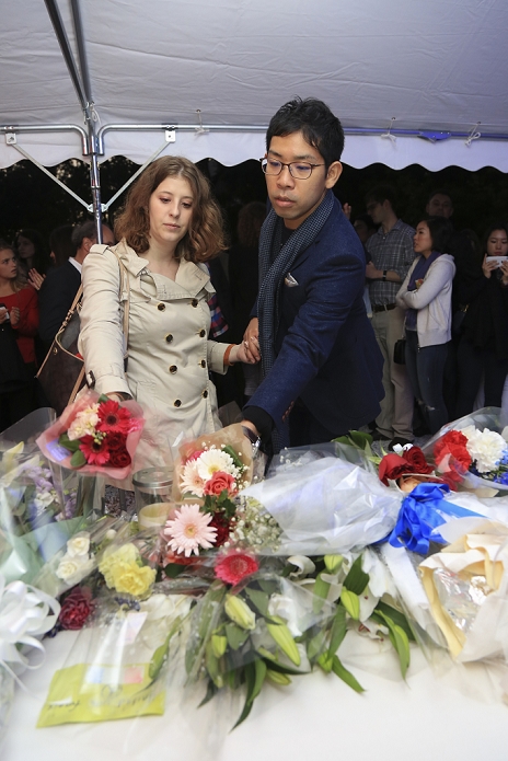 Paris Terrorist Attacks. Mourning the Victims in Tokyo People place flowers in a gesture of condolence and solidarity for the victims of the terrorist attacks in Paris on last Friday at the Embassy of France in Tokyo, Japan on November 15, 2015. In a gesture of condolence and solidarity with the French people the Chief Cabinet Secretary Yoshihide Suga, Tokyo Governor Yoichi Masuzoe and local Japanese and French attended a special ceremony at the Embassy of France in Tokyo. After the event a small group met outside Shibuya station to sing the Marseillaise. Tokyo also paid respect by illuminating Tokyo Tower and Tokyo Skytree in blue, white and red, the colors of the French flag.  Photo by Rodrigo Reyes Marin AFLO 