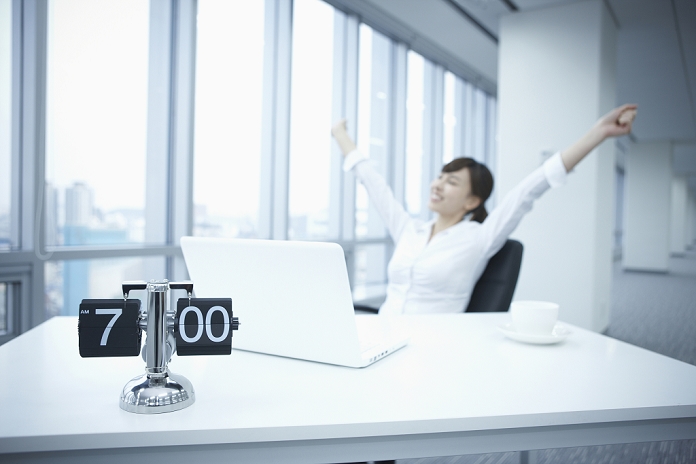 Business woman working at a desk businesswoman sitting at desk stretching her arms