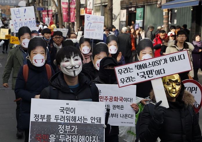 Massive Rally in  Masked  Form South Korea Protest against the Park Geun hye Administration Protest against Park Geun Hye, Dec 5, 2015 : Wearing masks people march during an anti government rally in Seoul, South Korea. The  People s Camp for Rising Up and Fighting , representing various groups of farmers, students, workers and the poor, demonstrated on December 5, 2015 to oppose Park s regime to change the labor market which protesters insist, will allow easier layoff and more temporary workers and to monopolize the authorship of history textbooks. People wore masks at the rally to denounce Park who recently compared local protestors in masks to ISIS. The organizer said 50,000 people participated in the demo, while the police estimated that 14,000 attended. A sign  front R  reads, We are not IS, we are people .  Photo by Lee Jae Won AFLO   SOUTH KOREA 