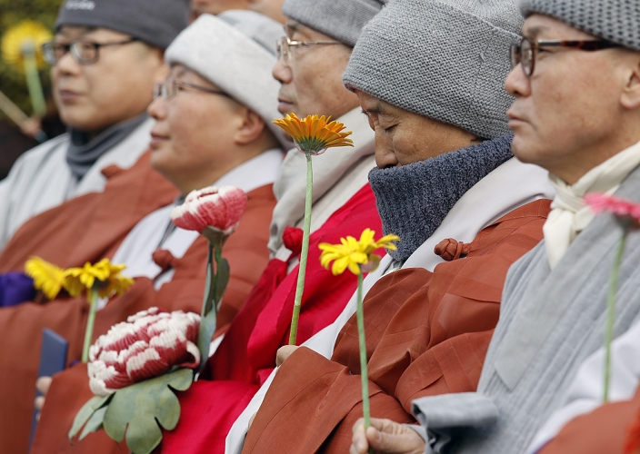 Massive Rally in  Masked  Form South Korea Protest against the Park Geun hye Administration Protest against Park Geun Hye, Dec 5, 2015 : Holding flowers, Buddhist monks attend an anti government rally in Seoul, South Korea. The  People s Camp for Rising Up and Fighting , representing various groups of farmers, students, workers and the poor, demonstrated on December 5, 2015 to oppose Park s regime to change the labor market which protesters insist, will allow easier layoff and more temporary workers and to monopolize the authorship of history textbooks. People wore masks at the rally to denounce Park who recently compared local protestors in masks to ISIS. The organizer said 50,000 people participated in the demo, while the police estimated that 14,000 attended.  Photo by Lee Jae Won AFLO   SOUTH KOREA 
