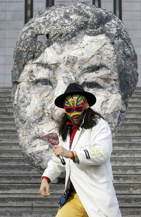 Massive Rally in  Masked  Form South Korea Protest against the Park Geun hye Administration Protest against Park Geun Hye, Dec 5, 2015 : An artist performs in front of a mask resembling South Korean President Park Geun Hye during an anti government rally in Seoul, South Korea. The  People s Camp for Rising Up and Fighting , representing various groups of farmers, students, workers and the poor, demonstrated on December 5, 2015 to oppose Park s regime to change the labor market which protesters insist, will allow easier layoff and more temporary workers and to monopolize the authorship of history textbooks. People wore masks at the rally to denounce Park who recently compared local protestors in masks to ISIS. The organizer said 50,000 people participated in the demo, while the police estimated that 14,000 attended.  Photo by Lee Jae Won AFLO   SOUTH KOREA 