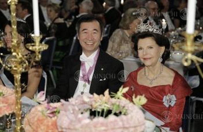 Nobel Prize 2015. Dinner in Stockholm Takaaki Kajita, left, director of the Institute for Cosmic Ray Research at the University of Tokyo, smiles at a dinner party following the Nobel Prize ceremony. At right is Queen Silvia at Stockholm City Hall, December 10, 2015, 7:50 p.m.  Representative photo 